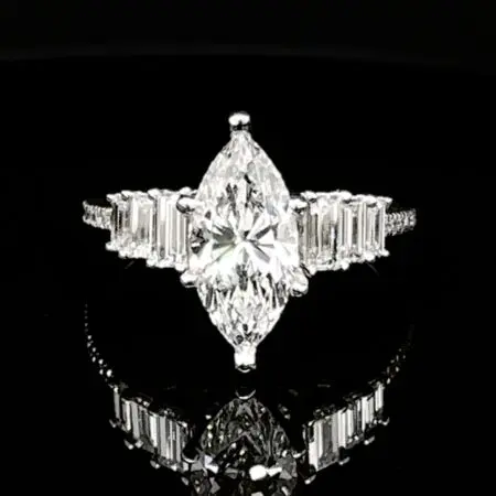Marquise diamond engagement ring with baguette side stones and a pavé white gold band