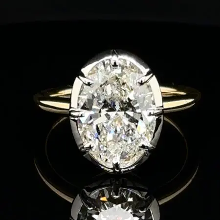 Large oval diamond solitaire with white gold prongs on a yellow gold band