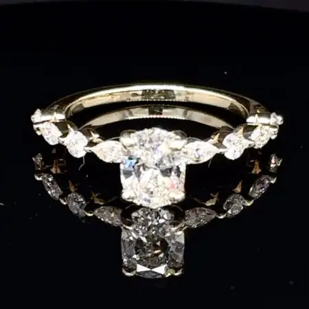 Cushion-cut diamond engagement ring with marquise and round diamonds along a yellow gold band