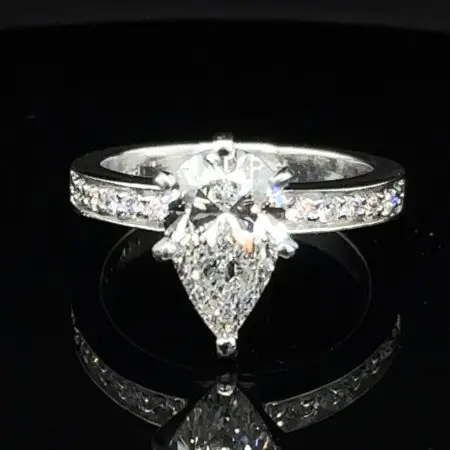 Pear-shaped diamond engagement ring with diamonds set along a white gold band