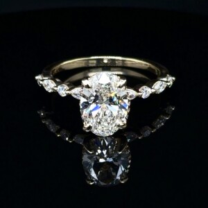 Large oval diamond engagement ring with marquise and round accent diamonds along the band