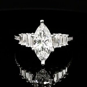Marquise diamond engagement ring with baguette side stones and a pavé white gold band